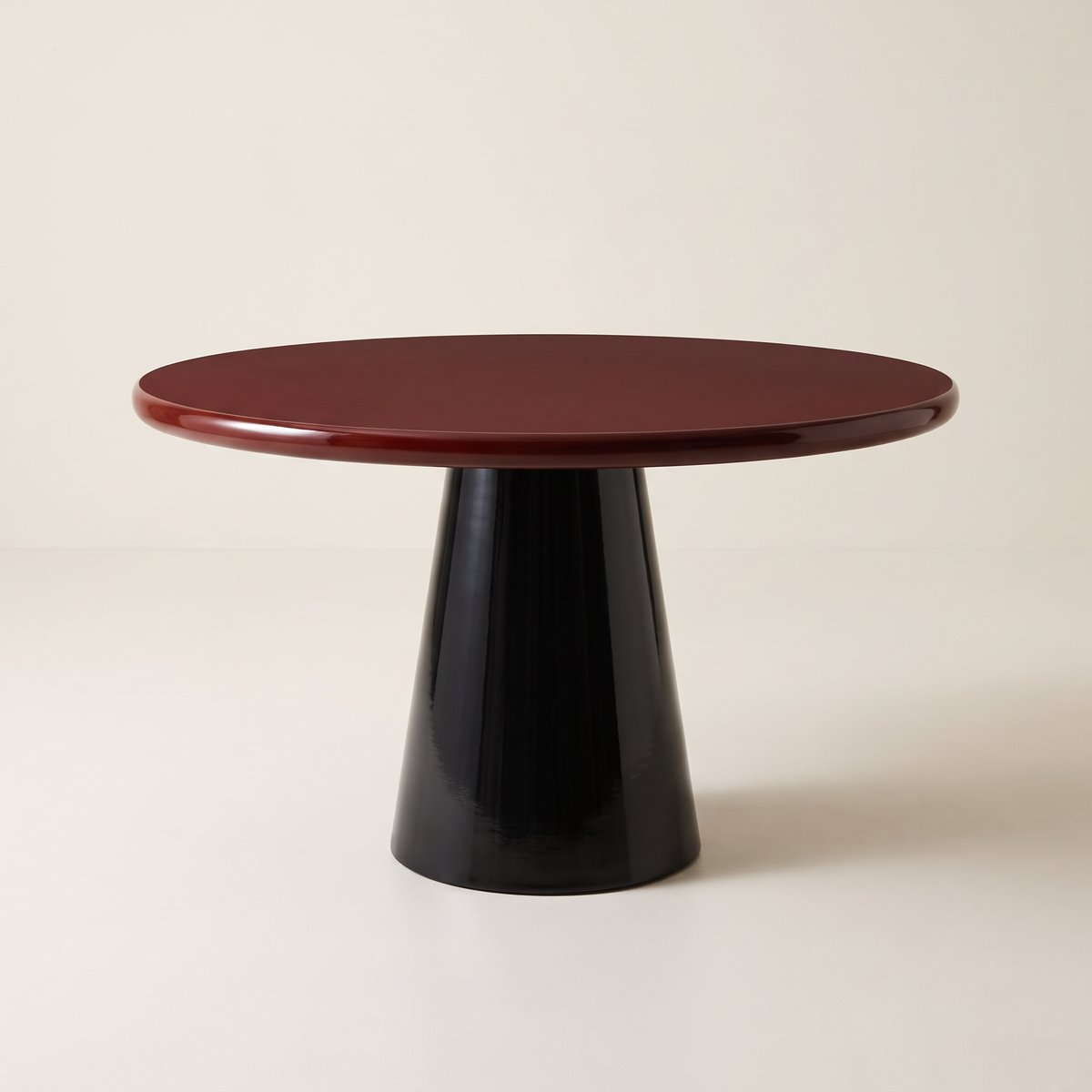 Obel round dining table with burgundy gloss top on a black conical pedestal base, front three-quarter view