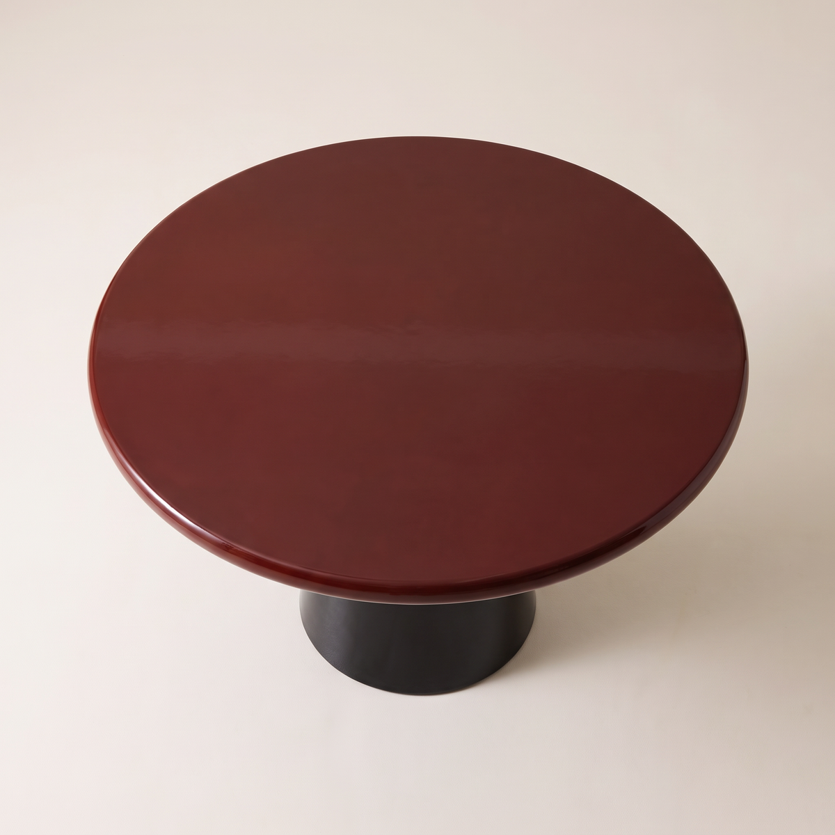 Obel round dining table with burgundy gloss top on a black conical pedestal base, high top view