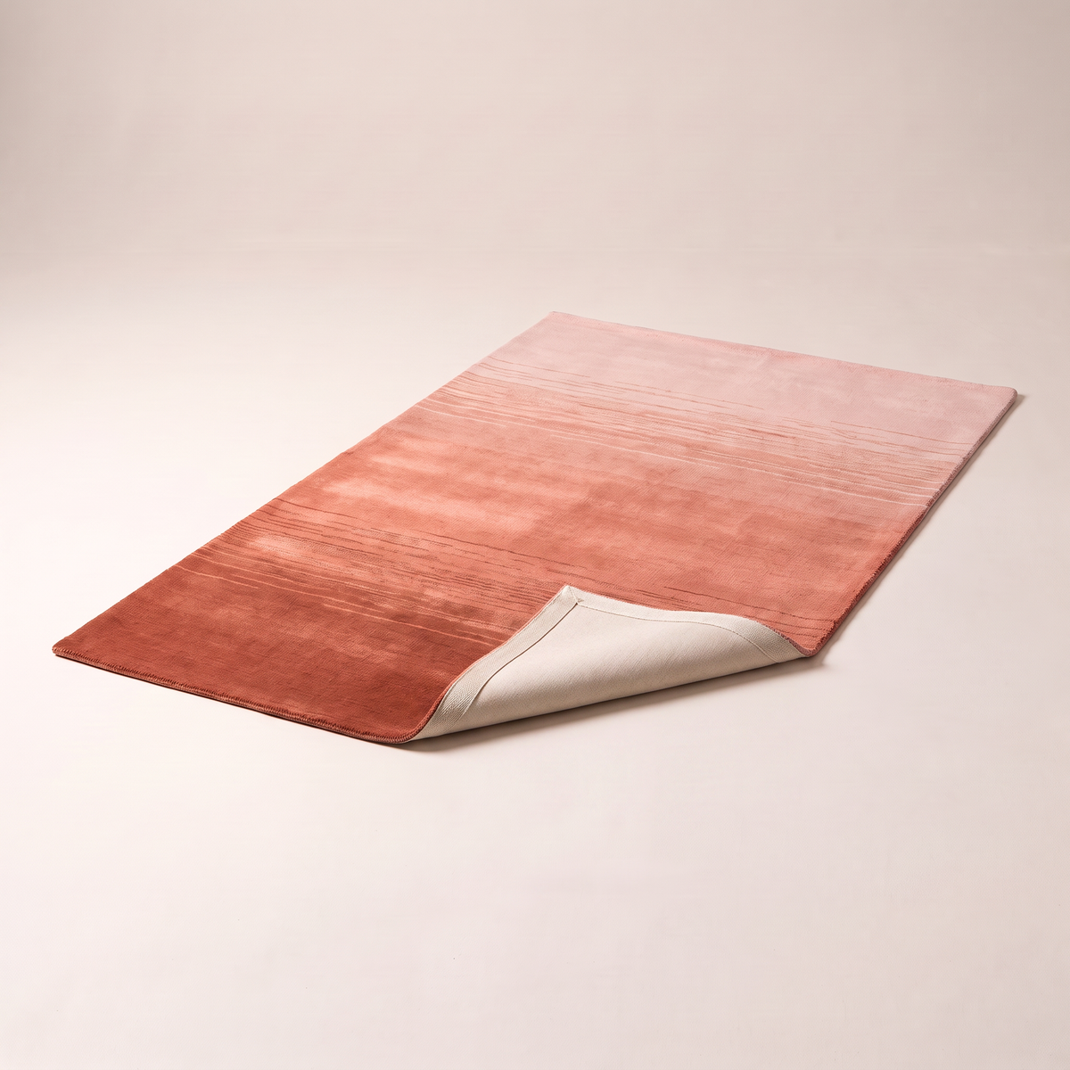 Ombre Dusk Rug with a corner folded back to show the cotton backing and edge finish