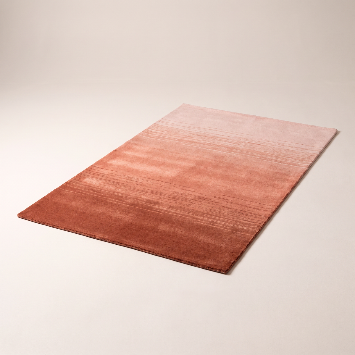 Ombre Dusk Rug, hand-loomed wool and viscose shading from rust to coral to blush, elevated three-quarter view