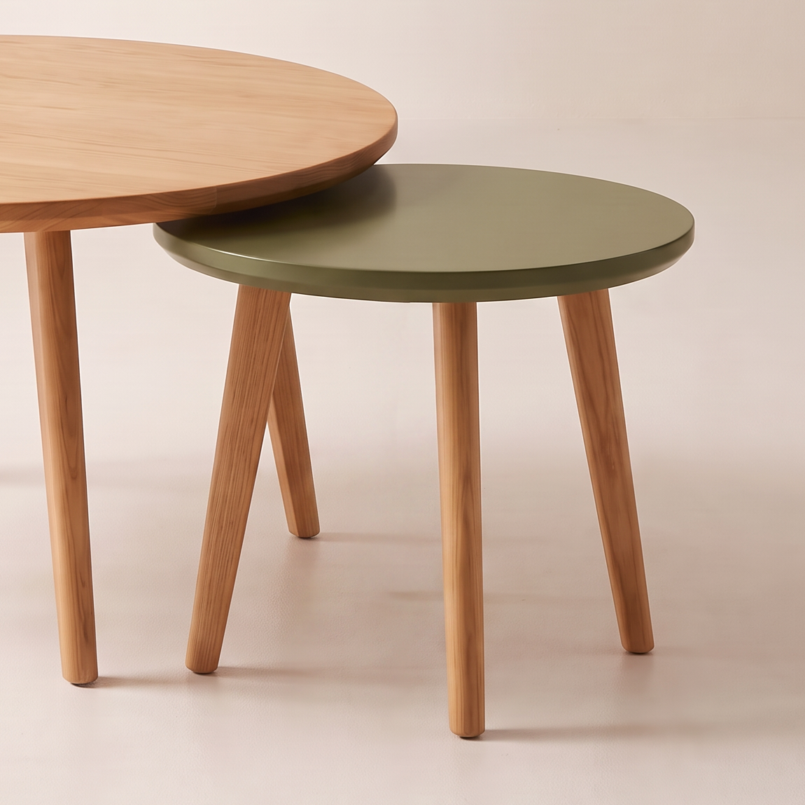 Orbit Nest detail: small olive lacquer table on four splayed ash legs nesting under the honey ash top