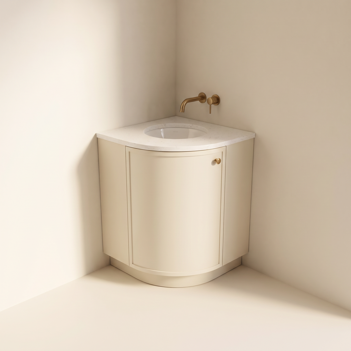 Petite Corner Vanity, quarter-round corner vanity in matte ivory with curved door, brass knob, white quartz top, round basin and brass wall tap, front view into the corner