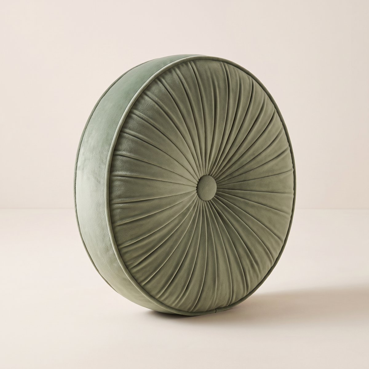 Pinwheel Round Cushion in sage velvet with radial pleats, centre button and boxed gusset, front three-quarter view