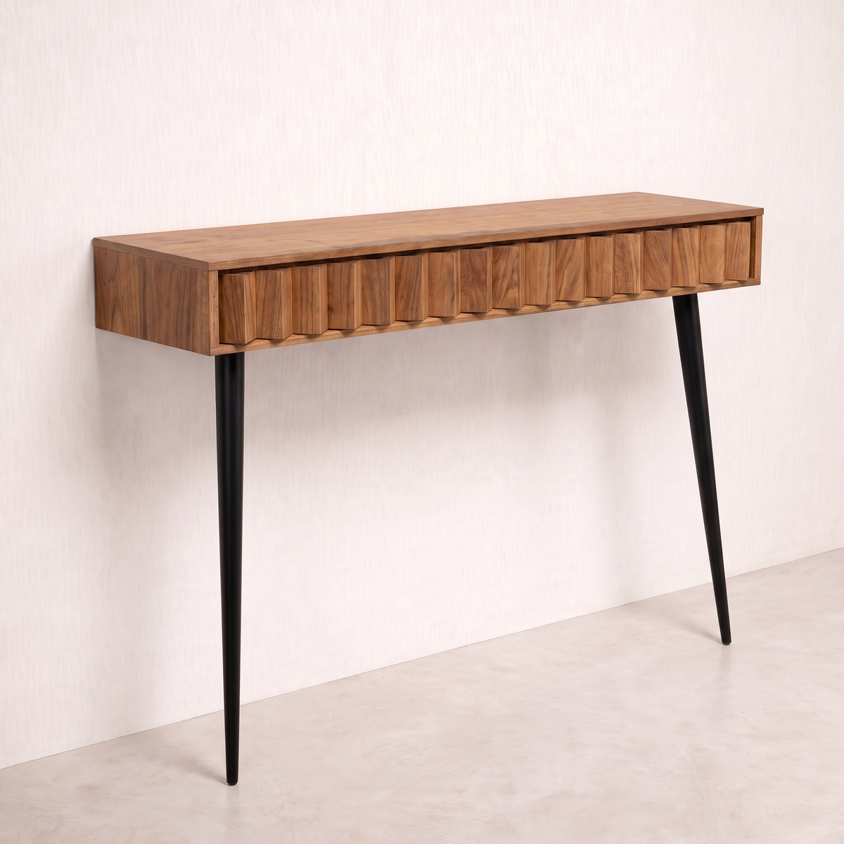 Pleat wall console in wood veneer with pleated front and two black tapered legs, front-right three-quarter view