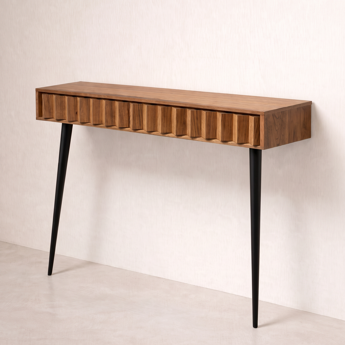 Pleat wall console in wood veneer with pleated front and two black tapered legs, front three-quarter view