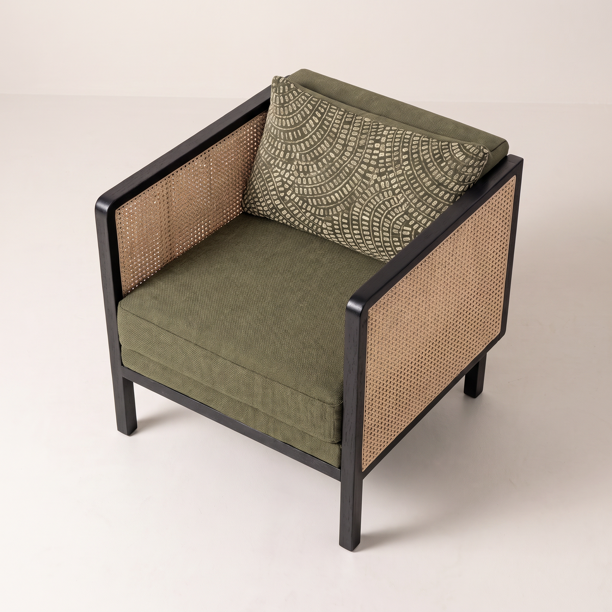 Raffia Black lounge chair, elevated three-quarter view showing the cushions and cane arms