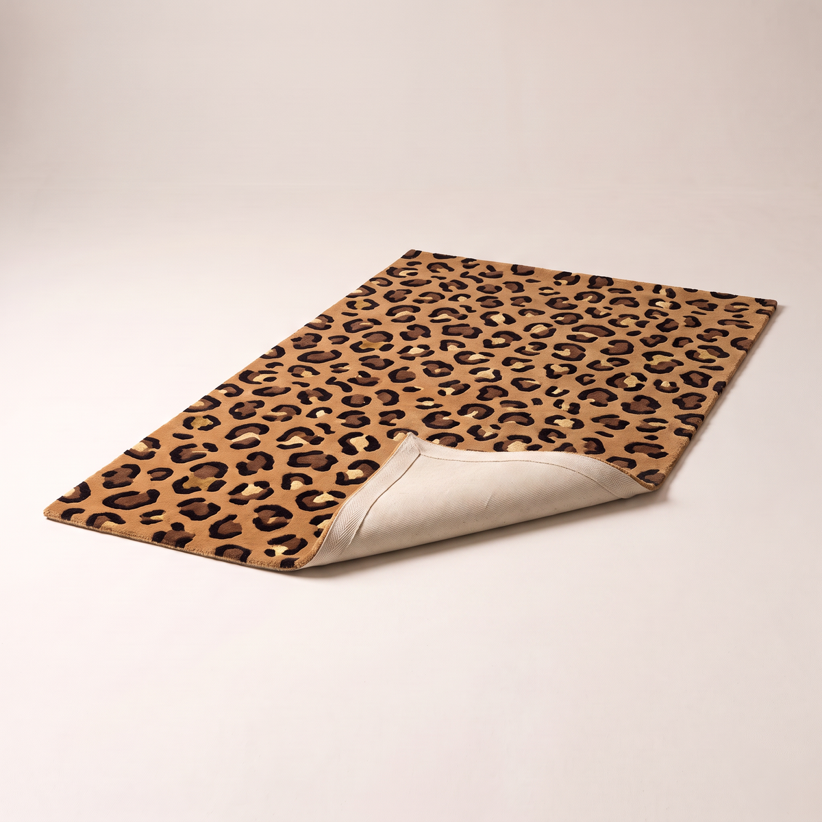 Rosette Leopard Rug with a corner folded back to show the cotton backing and bound edge