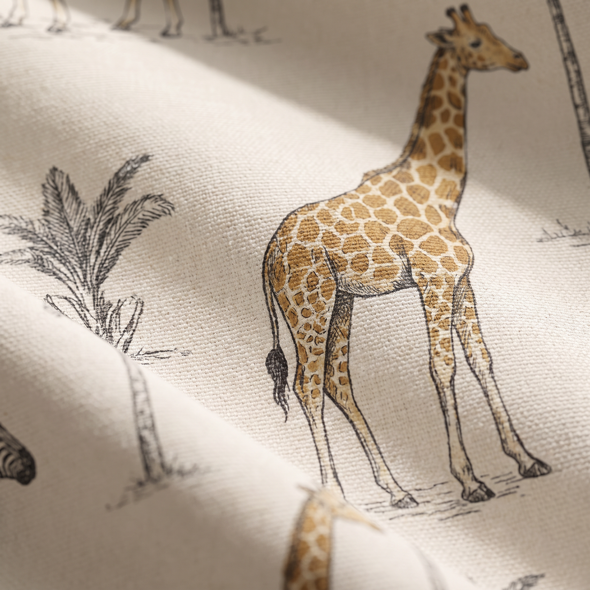 Safari Toile upholstery fabric, close-up of a printed giraffe in charcoal line work and ochre on cotton canvas