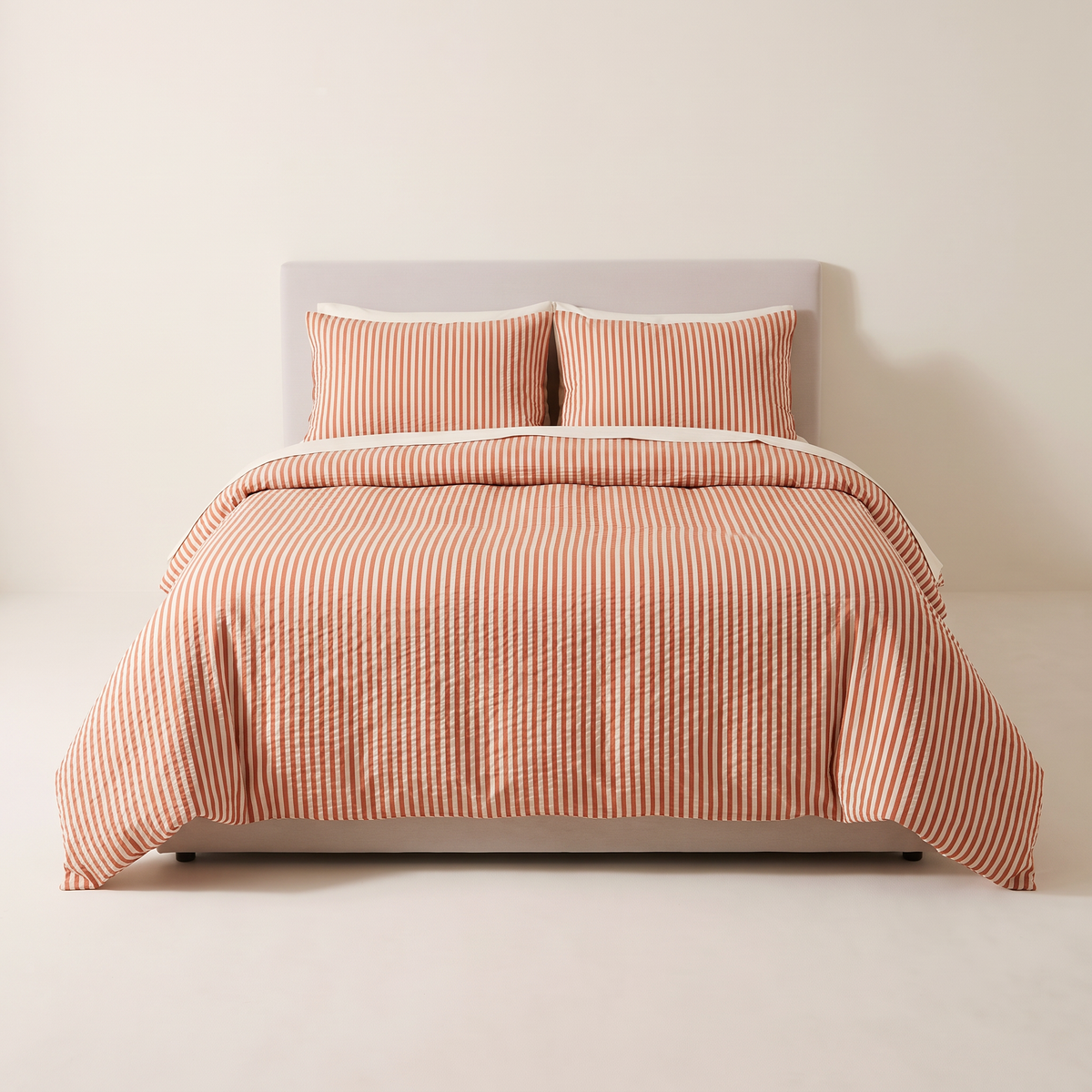 Seersucker Stripe Set rust and ivory striped duvet and shams, view from the foot of the bed