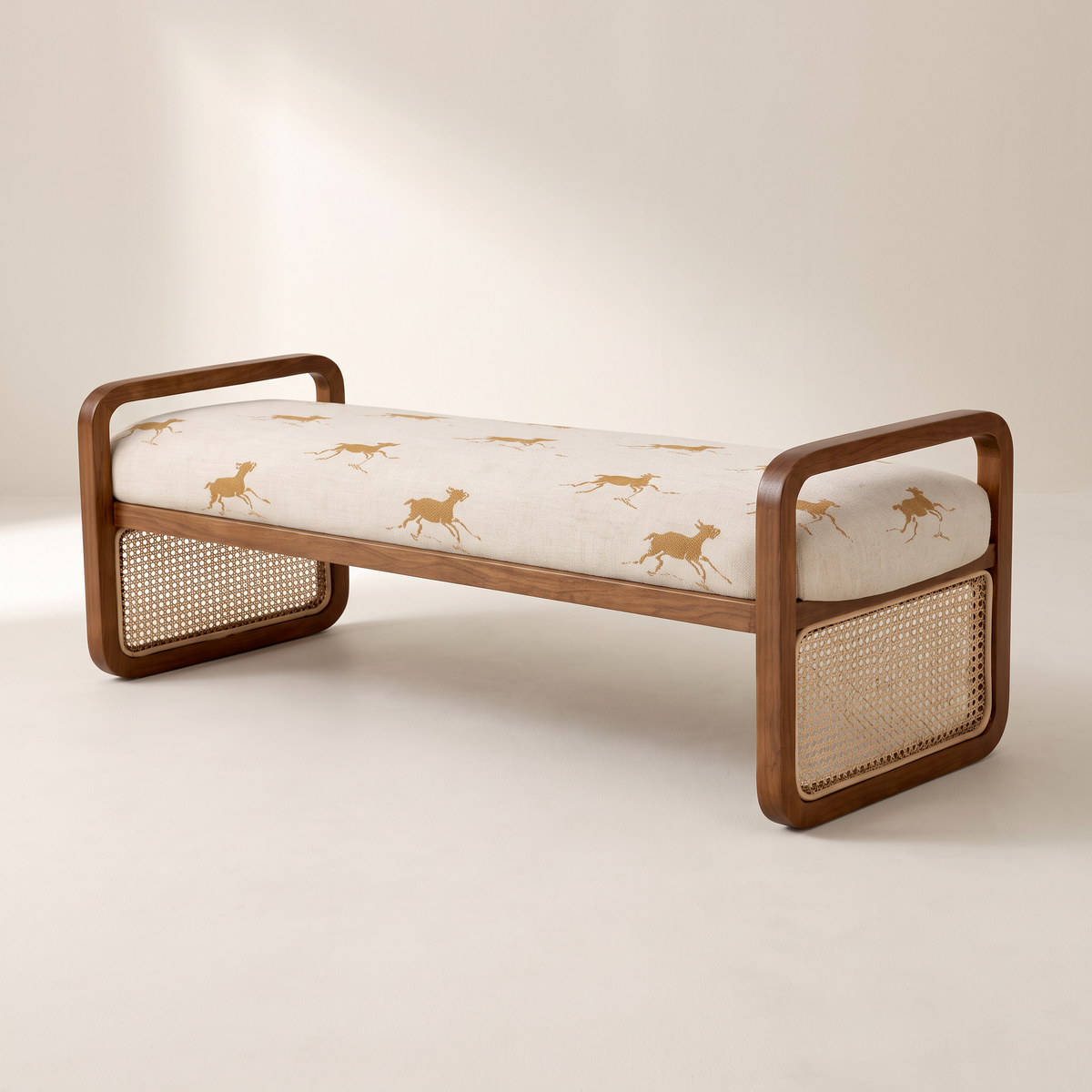 Serena Canter ottoman bench in cream galloping-horse print with walnut loop end frames and cane panels, front three-quarter view