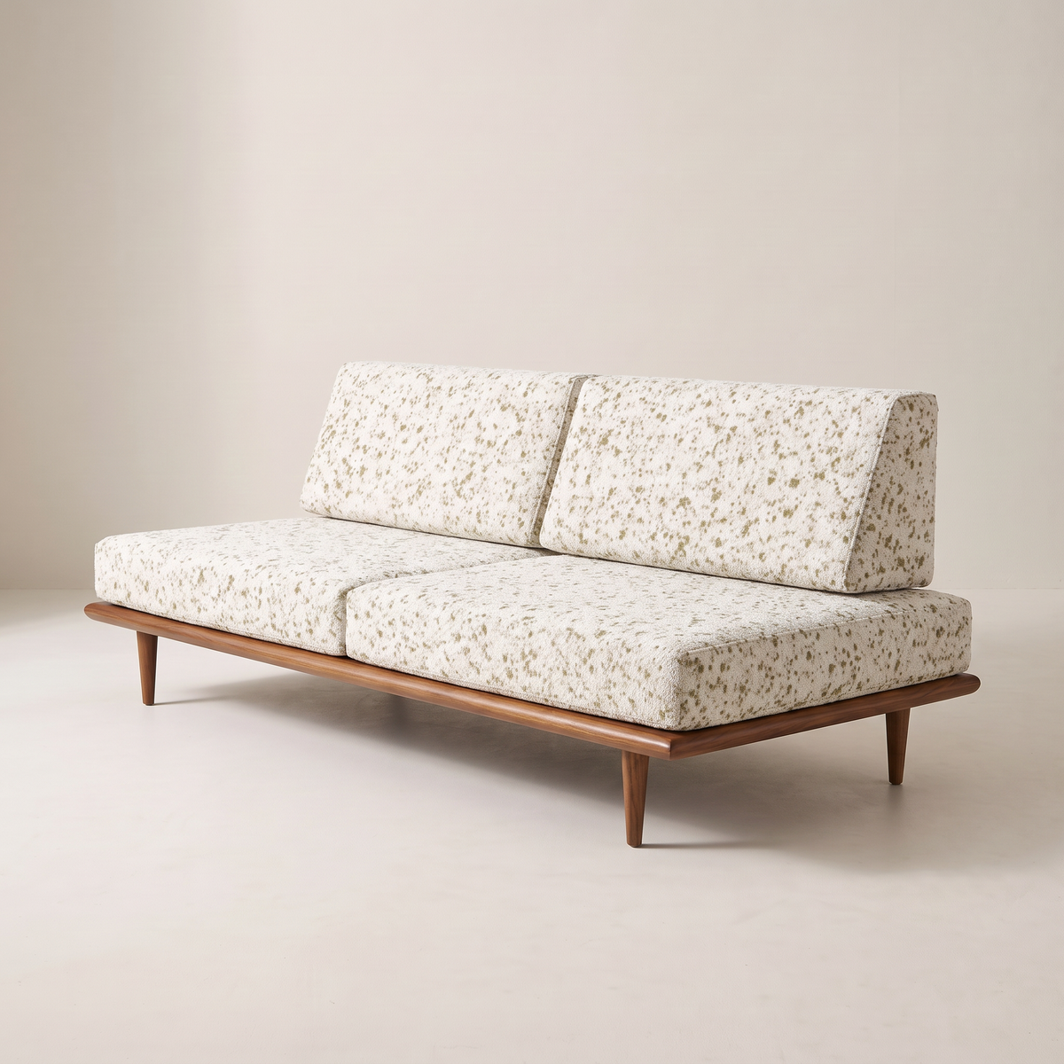 Slat Ivory armless sofa in ivory speckled upholstery on a walnut-tone wooden platform, front right three-quarter view