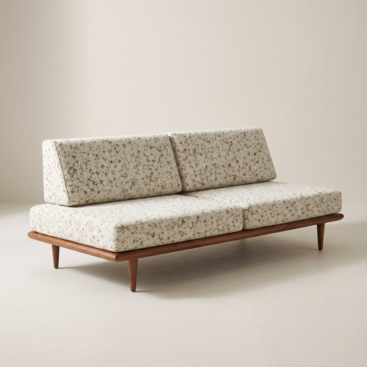 Slat Ivory armless sofa in ivory speckled upholstery on a walnut-tone wooden platform with tapered legs, front three-quarter view