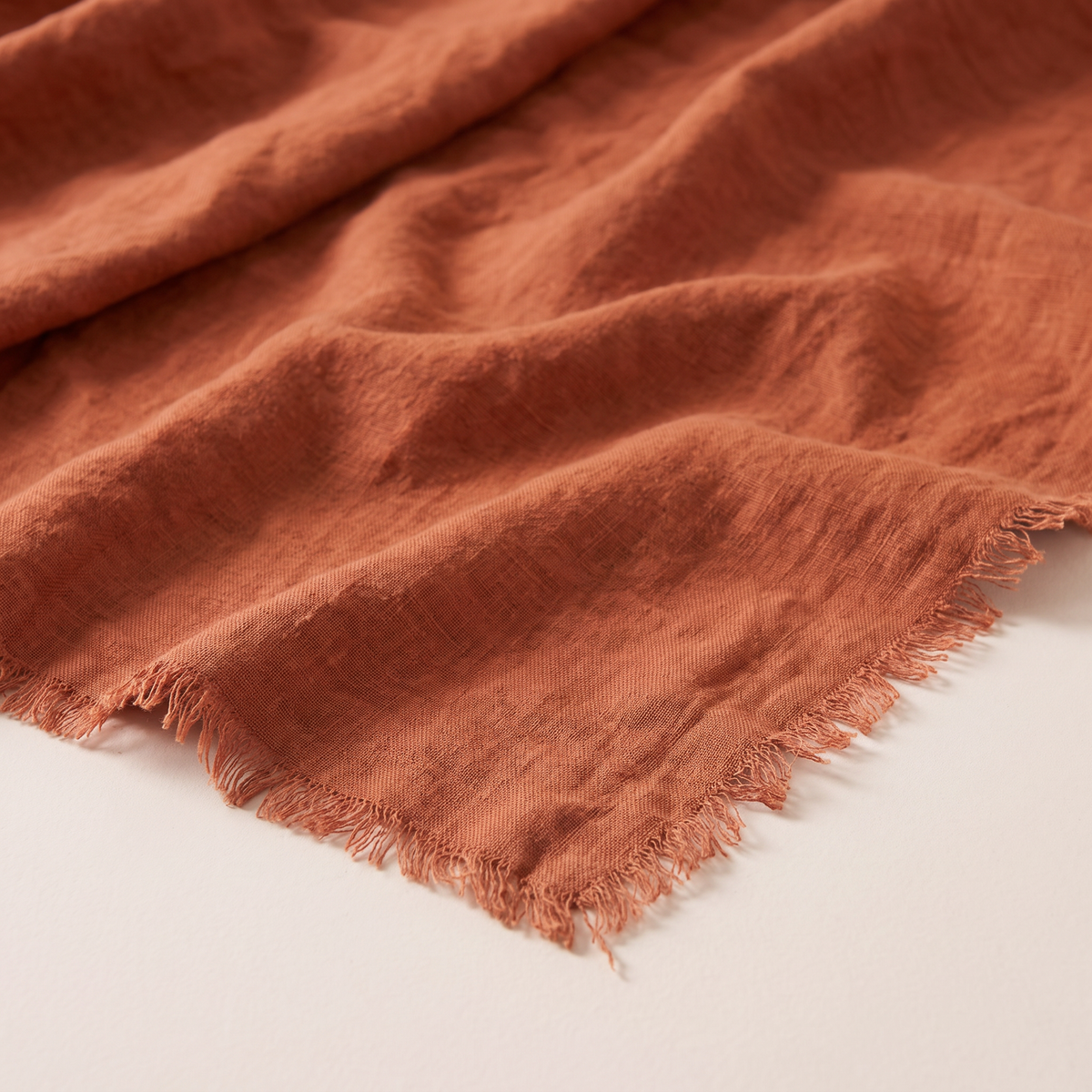 Stonewashed Linen Throw close-up of the washed rust linen texture and frayed edge