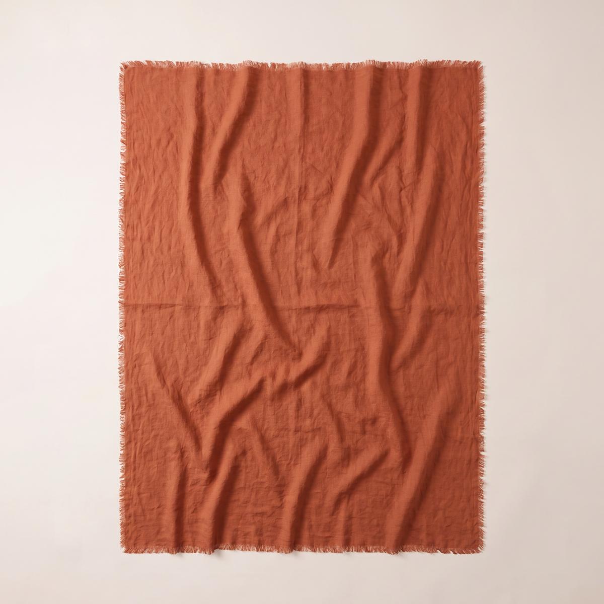 Stonewashed Linen Throw spread flat, overhead view of the whole rust linen throw with frayed edges