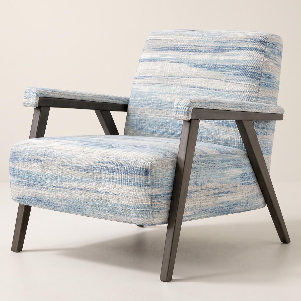 Strata Blue lounge chair in ivory and blue ikat-streaked fabric with slim dark wooden frame, front three-quarter view