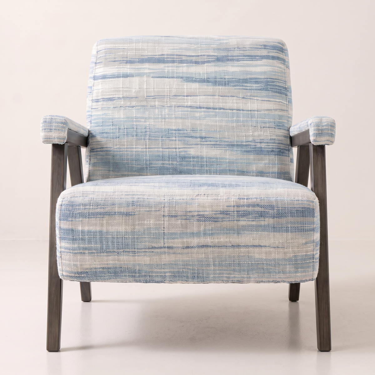 Strata Blue lounge chair in ivory and blue ikat-streaked fabric with slim dark wooden frame, front view