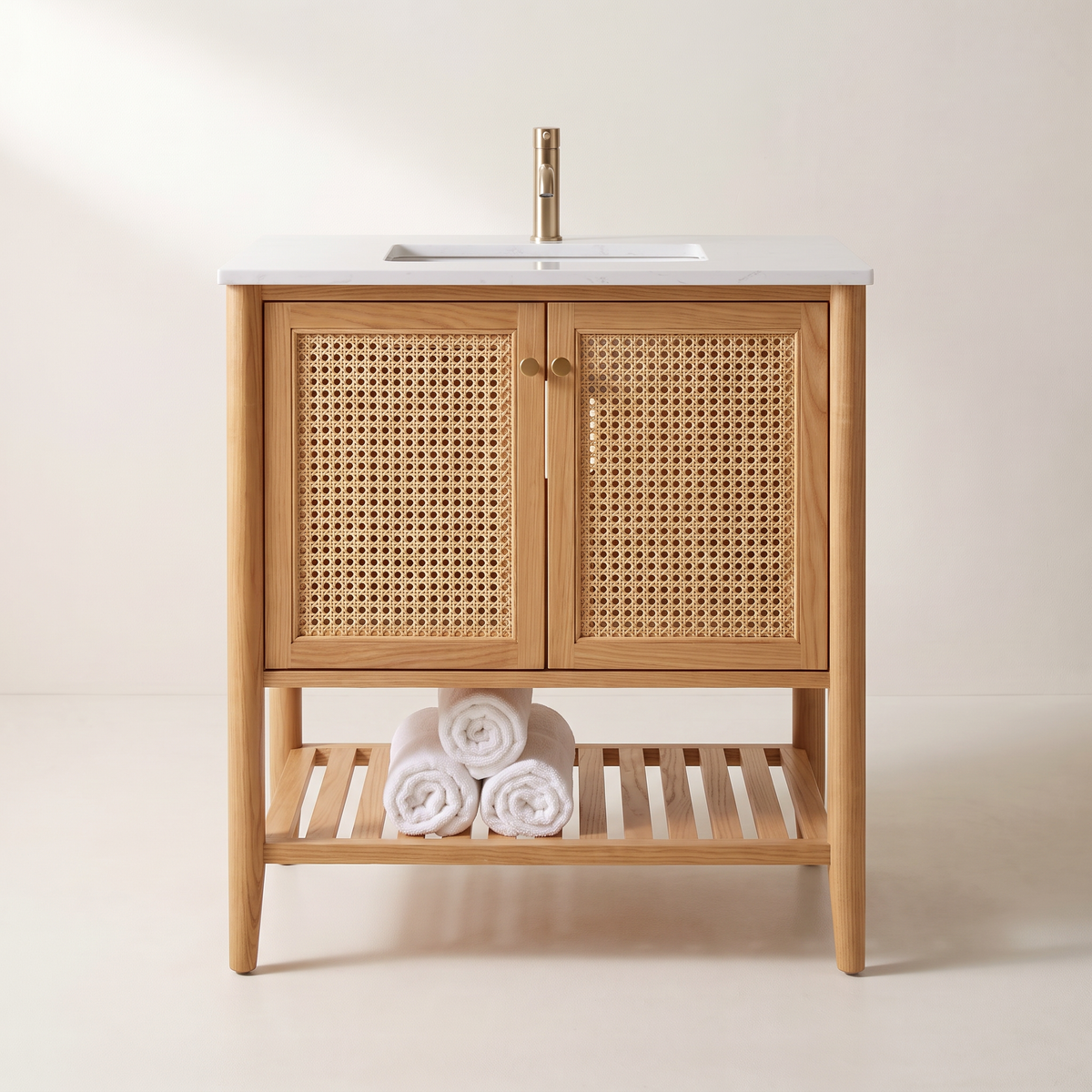 Tala Cane Vanity in honey ash with cane doors and slatted shelf holding rolled towels, straight front view