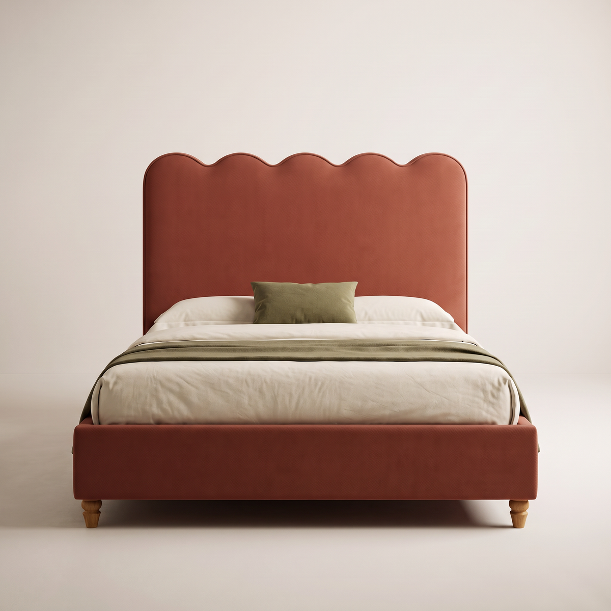 The Petal Bed seen from the foot, showing the scalloped rust headboard and ivory bedding with olive accents