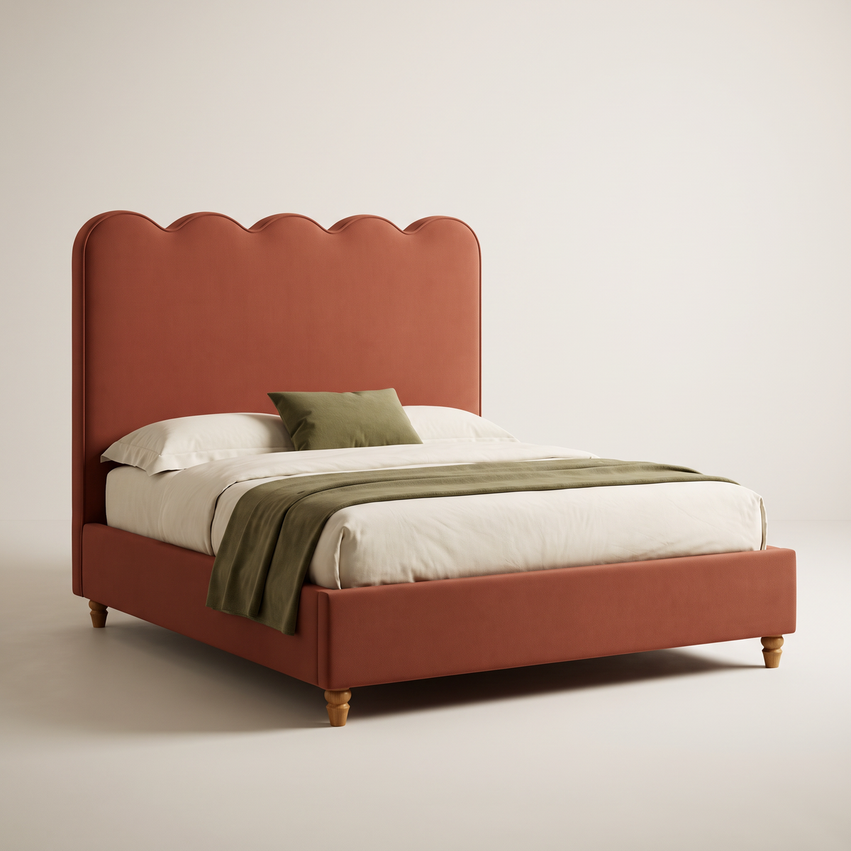 The Petal Bed in rust-terracotta upholstery with a piped five-scallop headboard and turned ash feet, three-quarter view