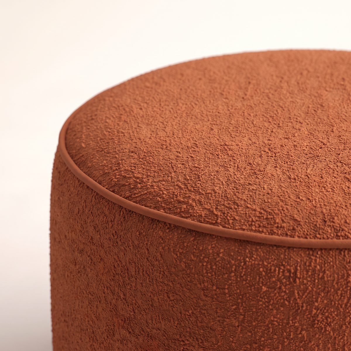Tondo Rust ottoman close-up of the rust bouclé texture and welt piping on the top edge