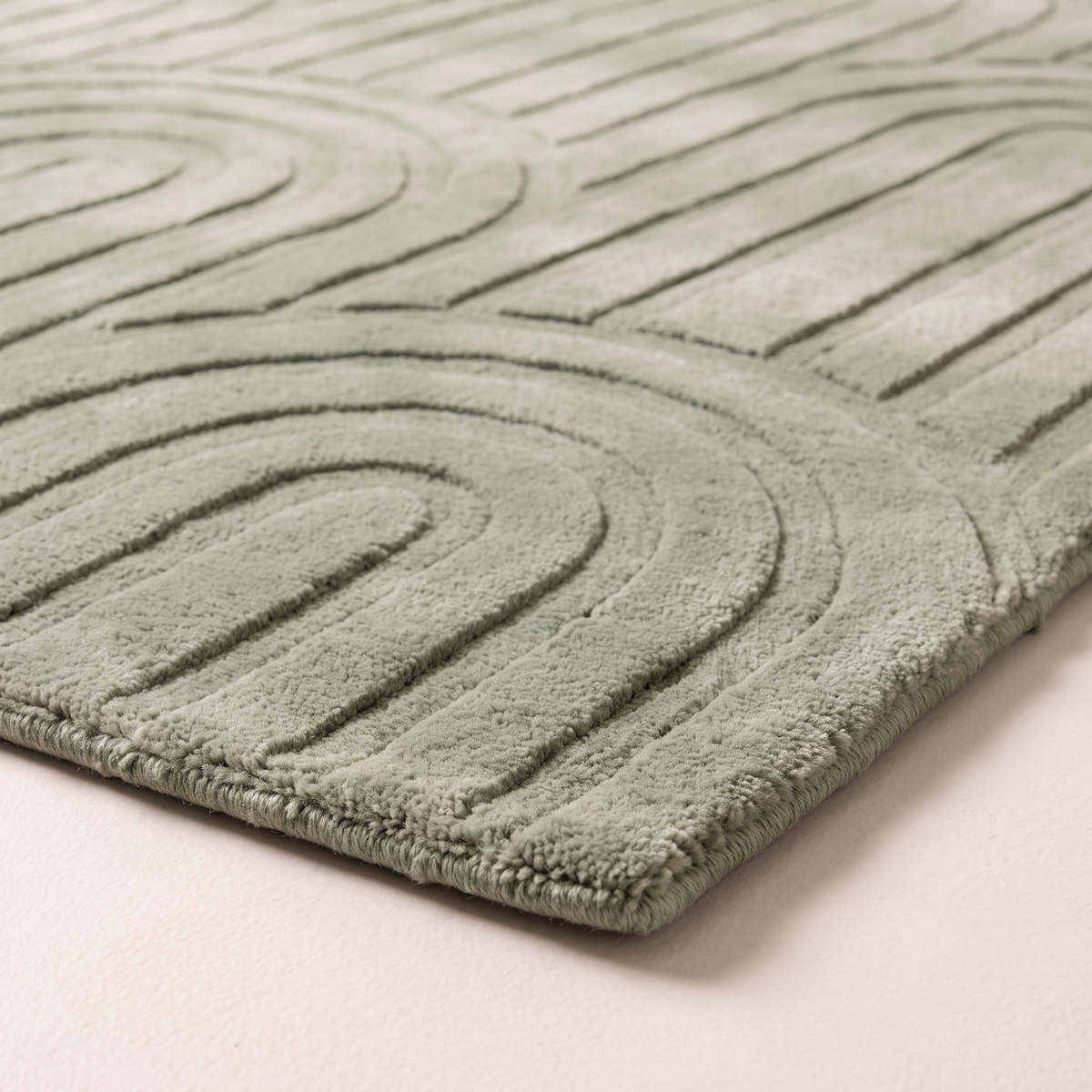Vault Sage Rug corner close-up showing carved high-low wool pile and bound edge