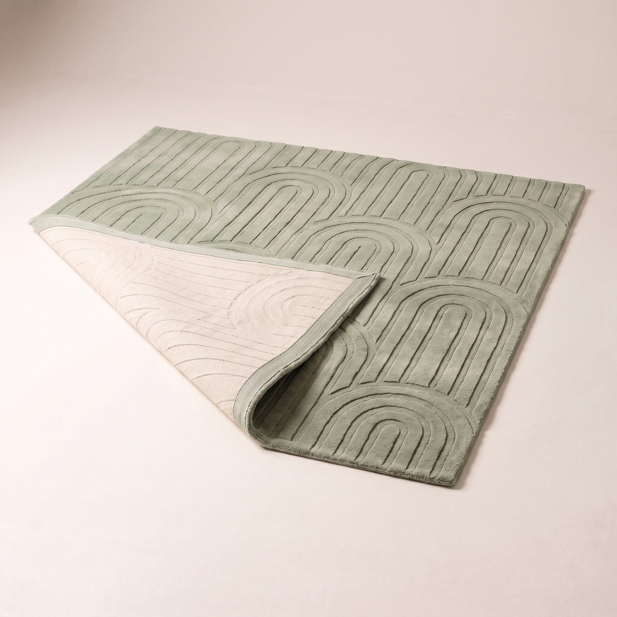 Vault Sage Rug with one corner folded back to show the cotton backing and edge finish