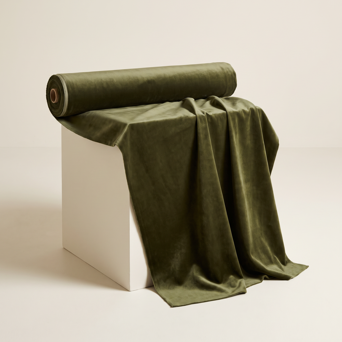 Velvet Olive upholstery fabric, deep olive velvet with soft sheen, unrolled from a bolt and draped over a studio plinth