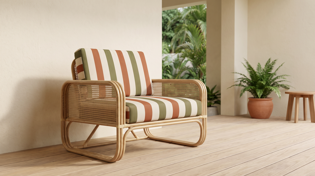 Verandah Stripe fabric shown on the cushions of a cane lounge chair on a covered verandah