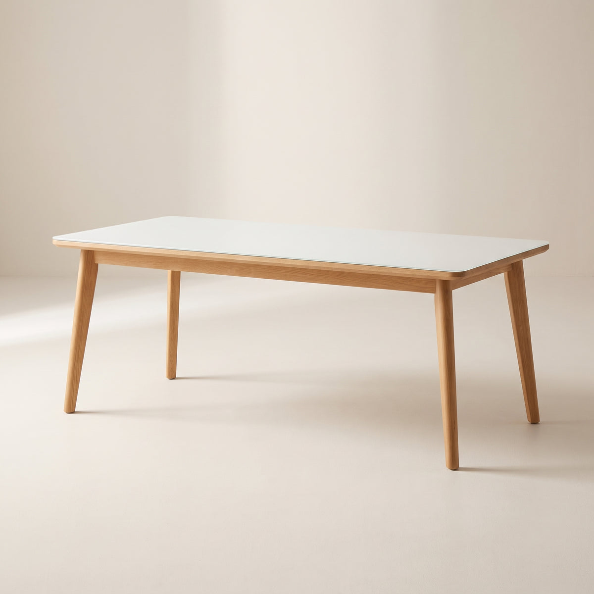 Vista Dining Table with white glass top and light wood frame with splayed tapered legs, three-quarter view