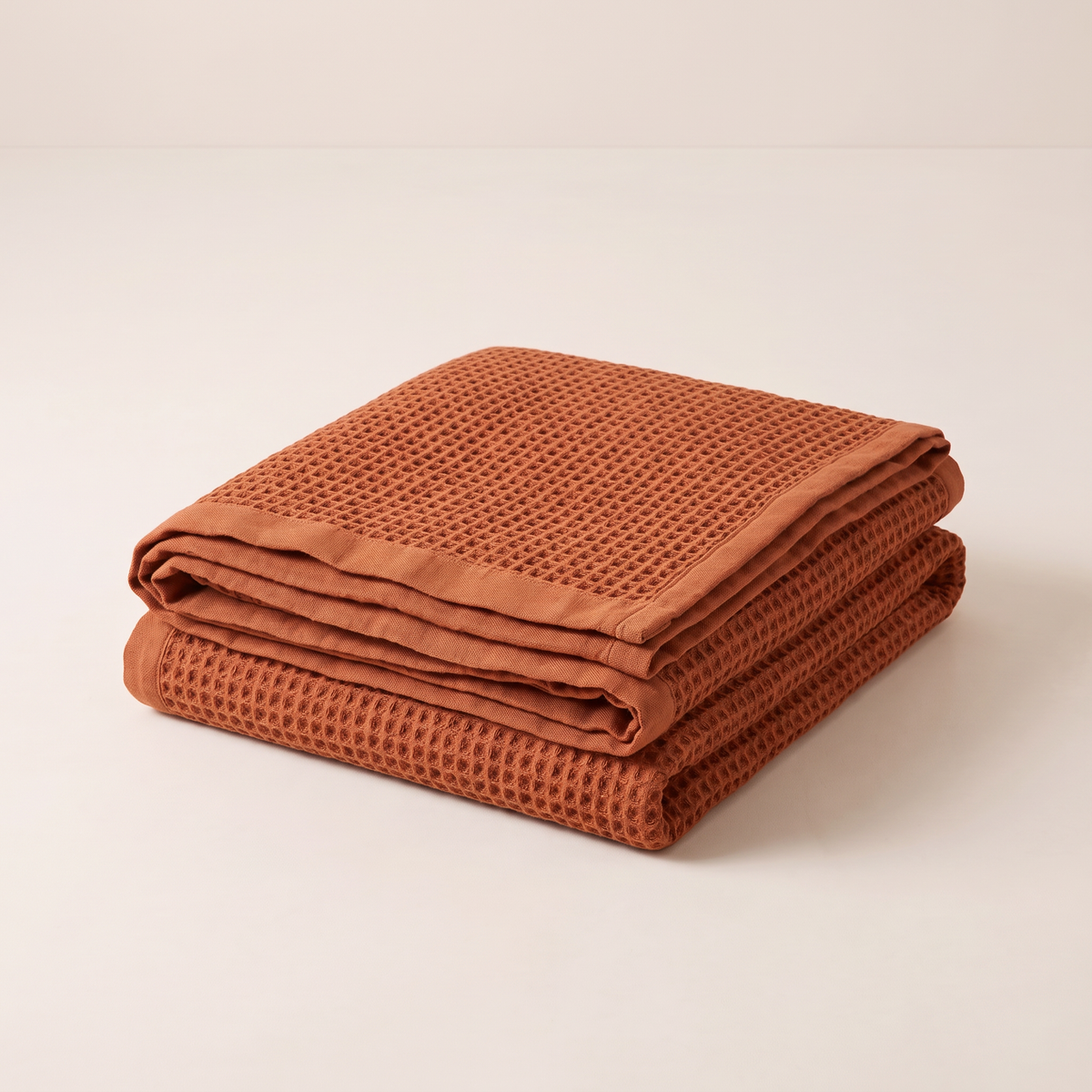 Waffle Cotton Throw in rust cotton waffle weave, folded neatly