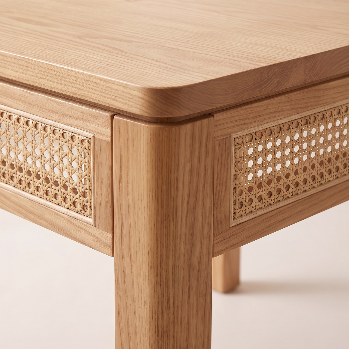 Weft Square dining table close-up of the corner showing woven cane apron panels framed in ash and the square leg