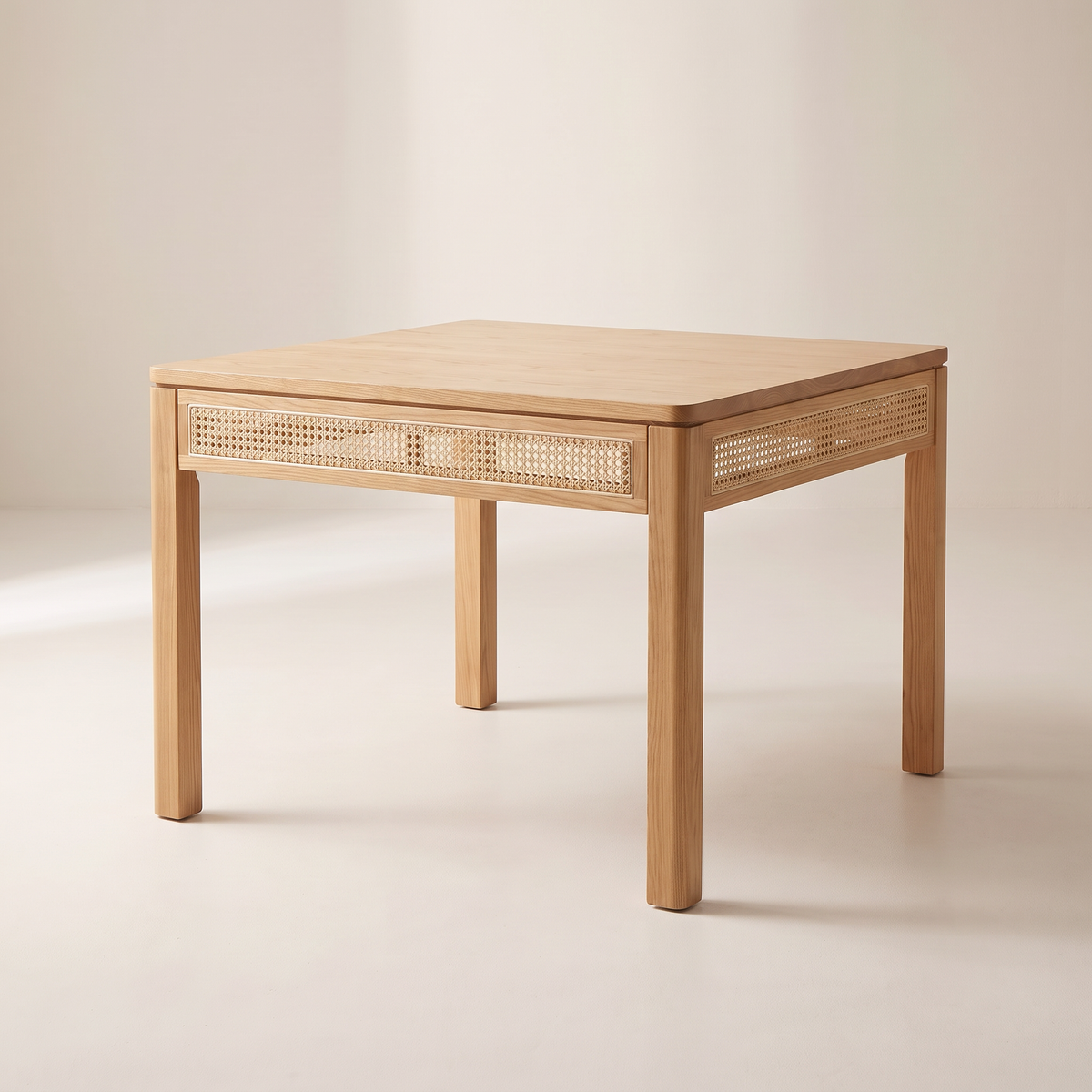 Weft Square dining table in honey ash with woven cane apron panels on all four sides and straight square legs, front three-quarter view