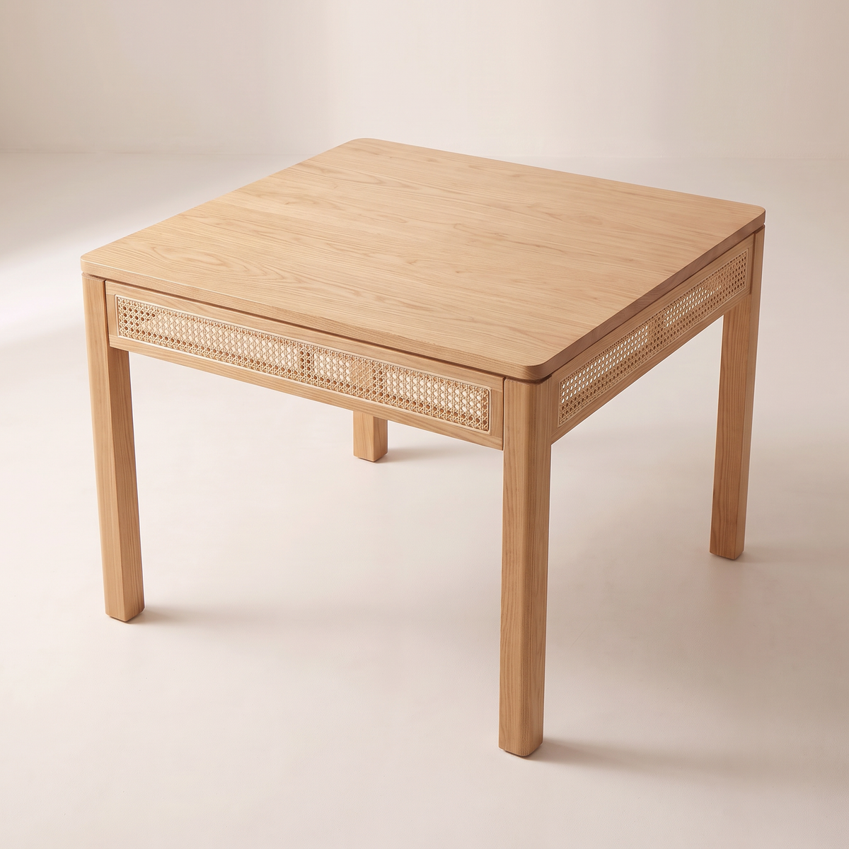 Weft Square dining table showing its square ash top with rounded corners and cane aprons, elevated three-quarter view
